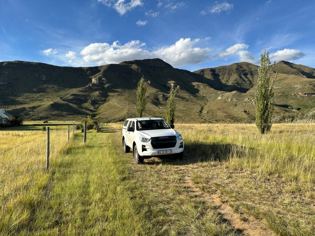 Witte 4x4 met bergen op achtergrond.