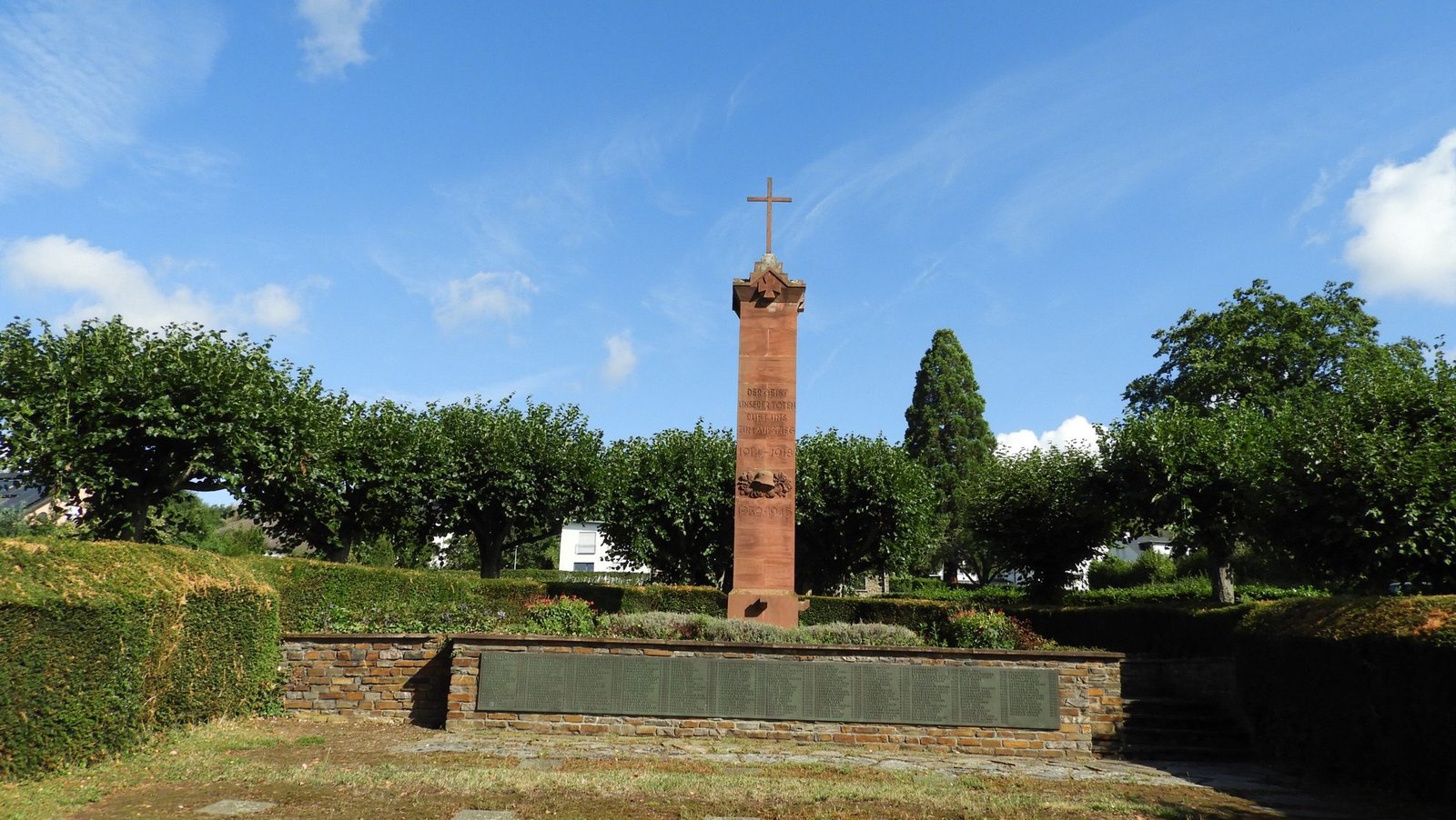 Smalle rode toren op kerkhof.