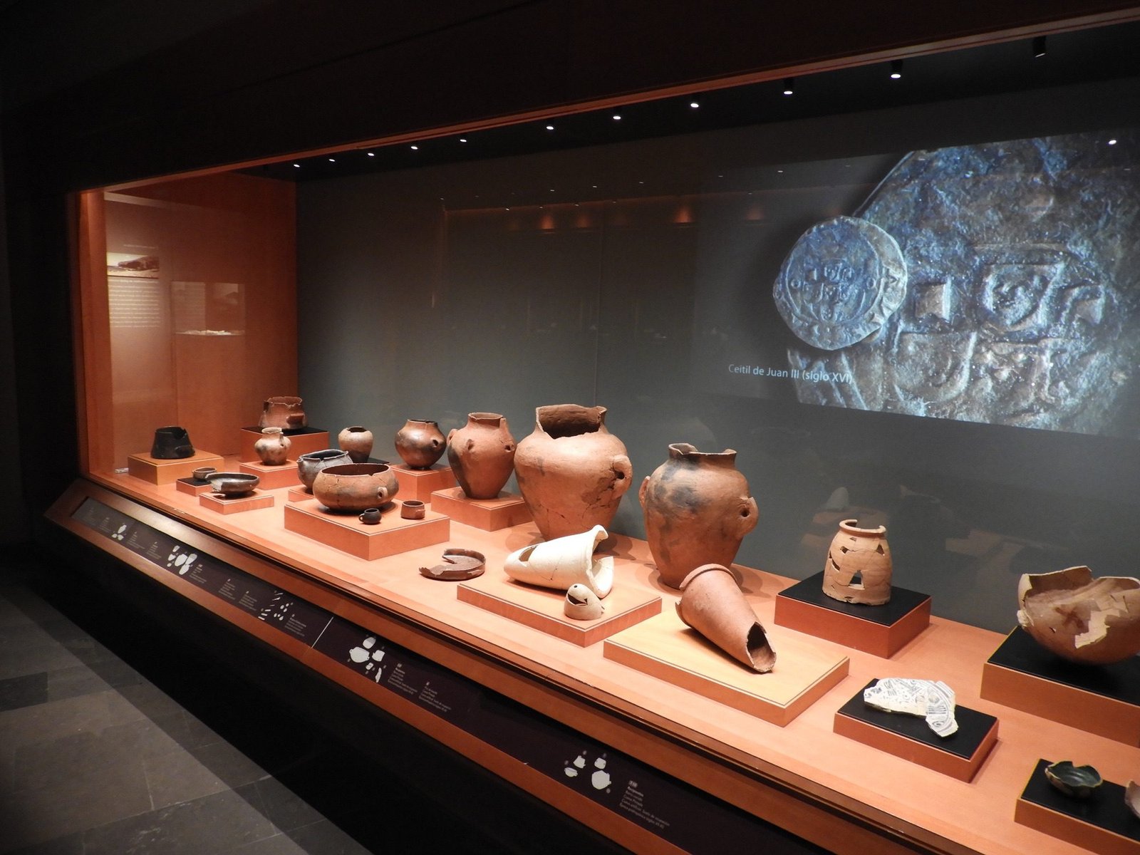 Uitgestald oker-bruin aardewerk in museum.