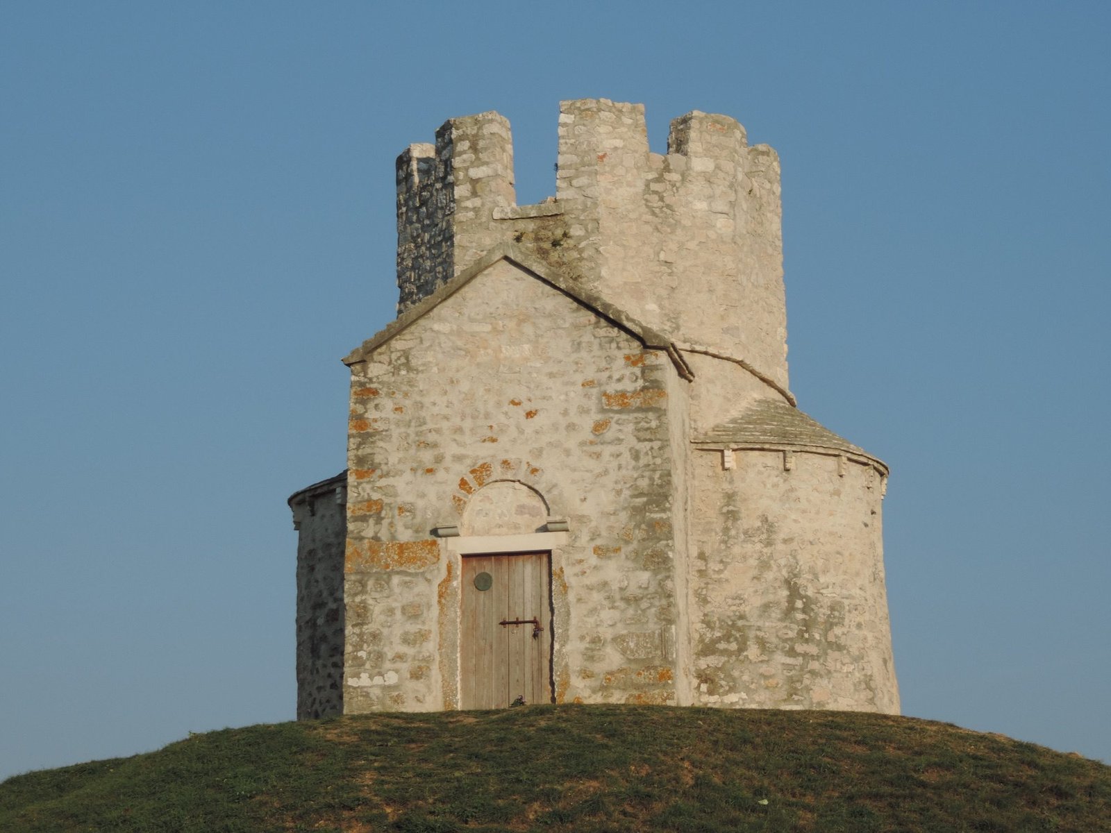 Witte kapel met versterkte toren.