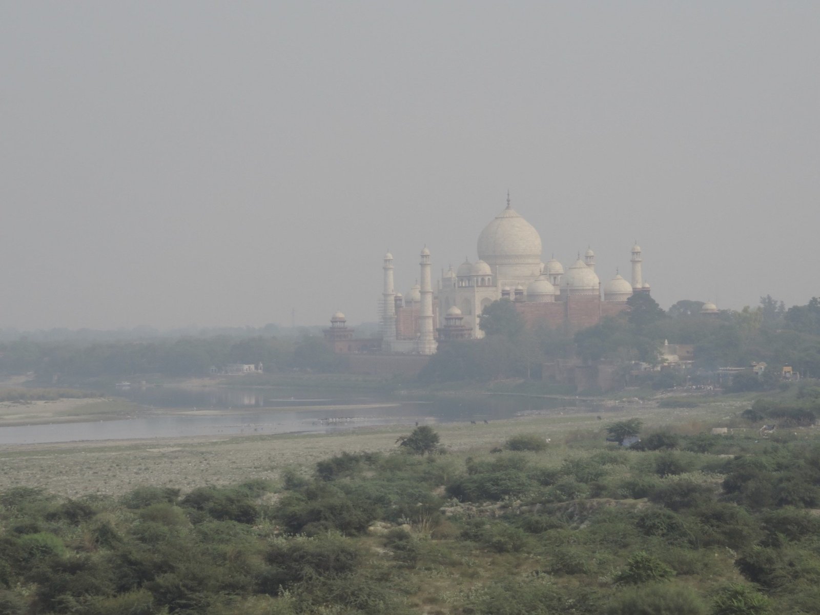Vergezicht over rivier met Taj Mahal in de achtergrond.