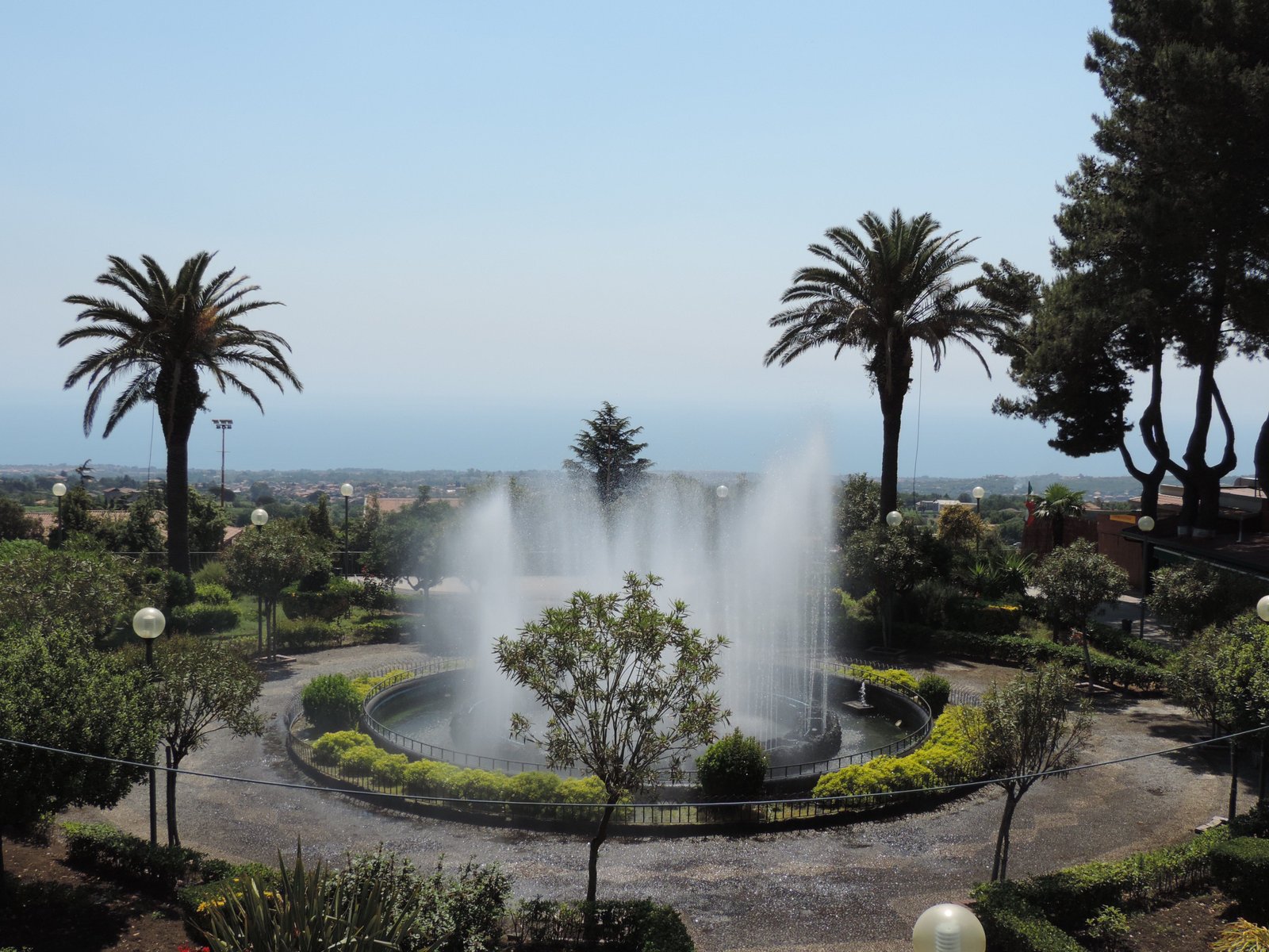 Fontein, palmbomen, zicht vanaf Zafferana.