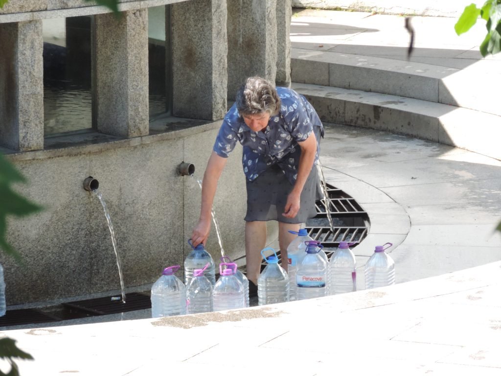 Luso: vrouw tapt bronwater.
