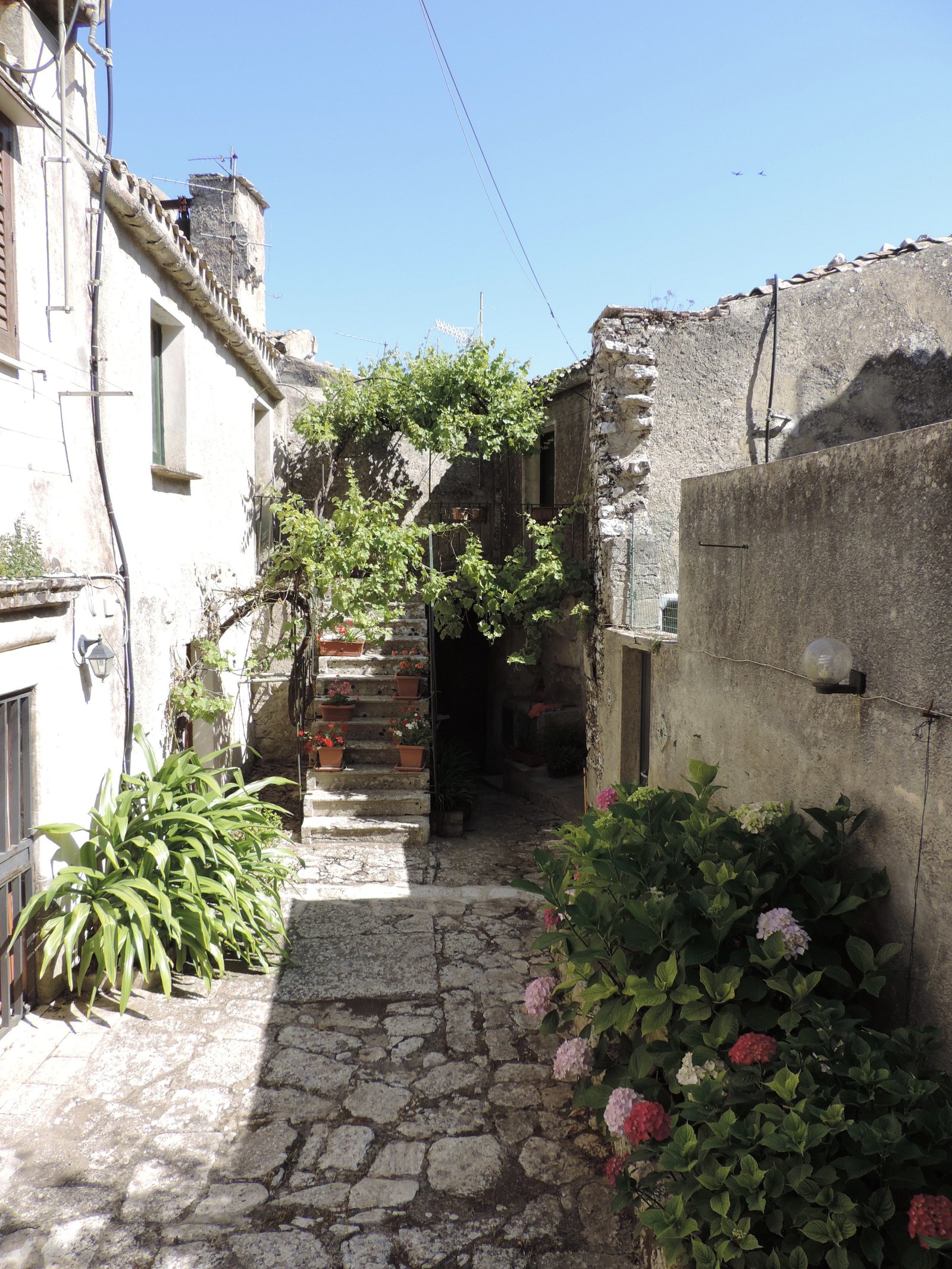 Straatje met trappen en bloemen in Erice.