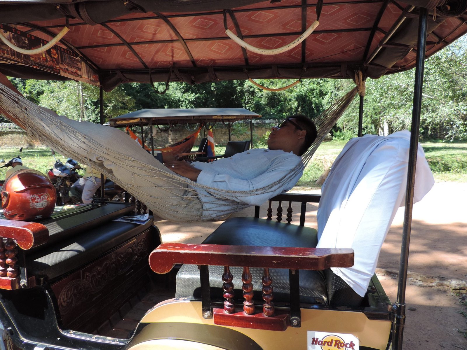 Slapende tuk-tuk chauffeur in hangmat in tuk-tuk.