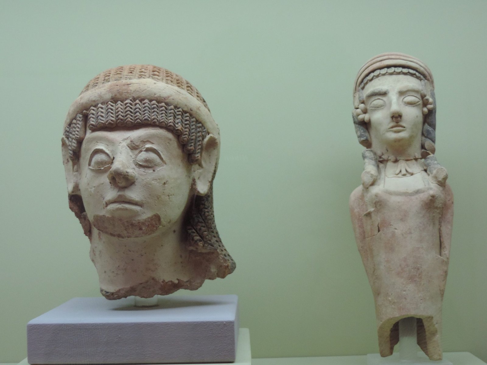 Twee beelden - een hoofd en een torso met hoofd - in museum.