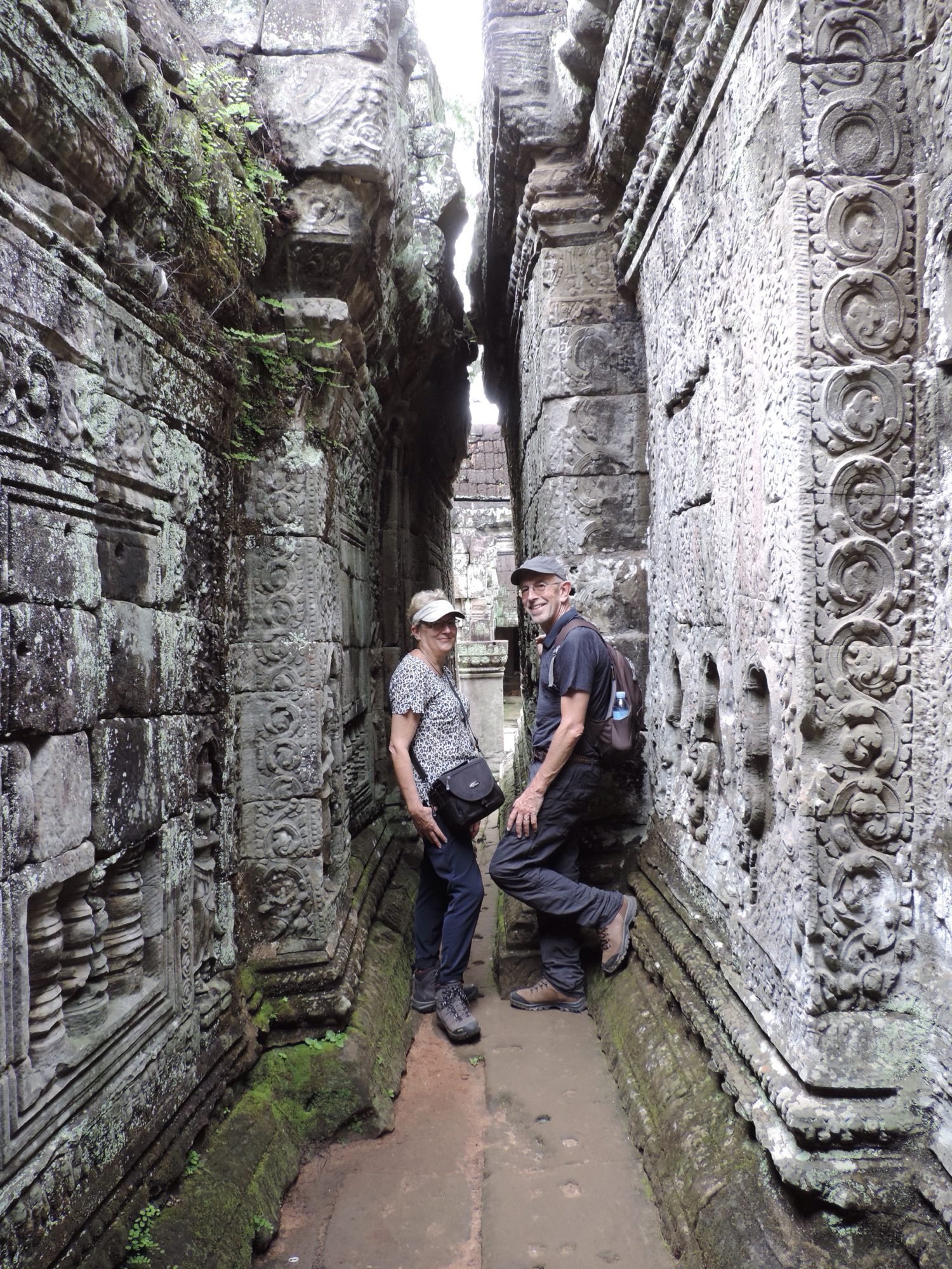 Twee toeristen in smalle tempel-doorgang.