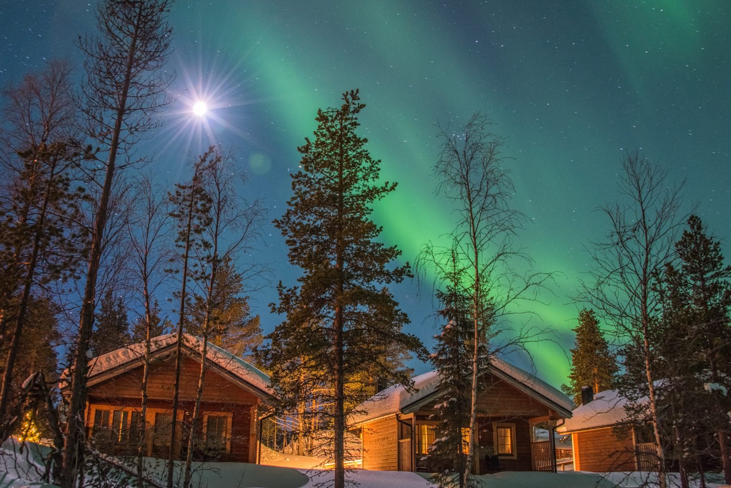 Aurora Borealis boven houten, verlichte huizen.