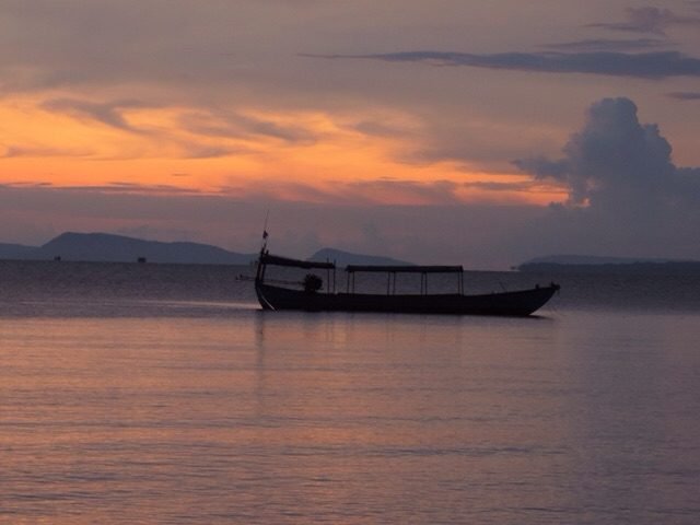 Zonsondergang over zee met boot.