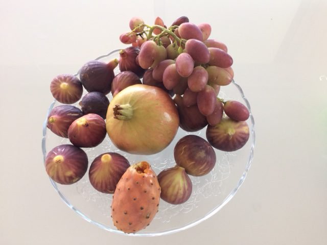 Glazen schaal met druiven, vijgen en prickly pear.