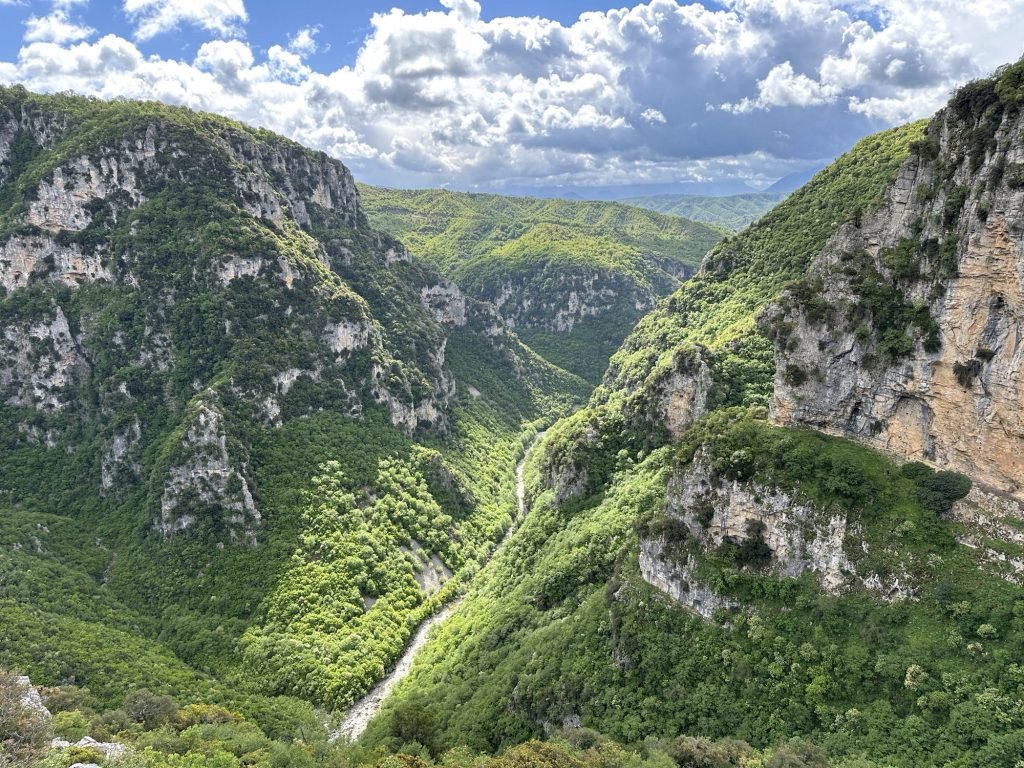 Vikos-kloof: diepe kloof in het groen met dreigende wolken in Centraal Griekenland