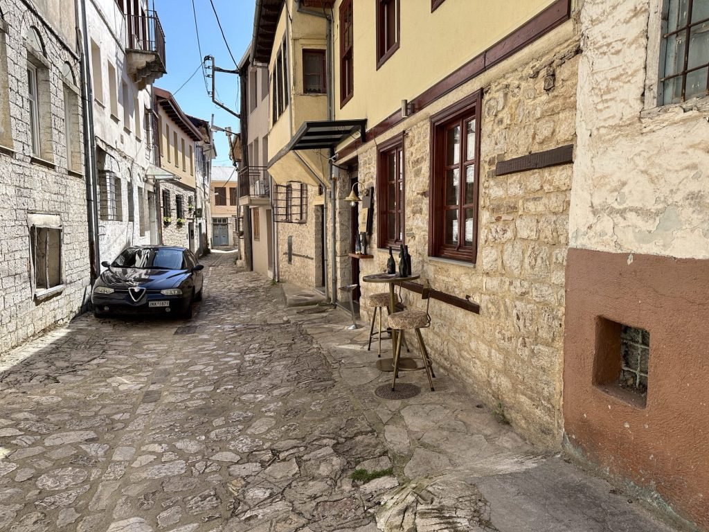 Kasseistraatje met oude huizen en één auto in Ioannina, Centraal Griekenland