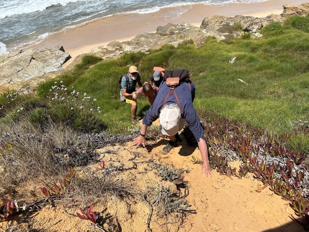 Toeristen, verrast door de vloed, kruipen de rotsen op in Porto Covo