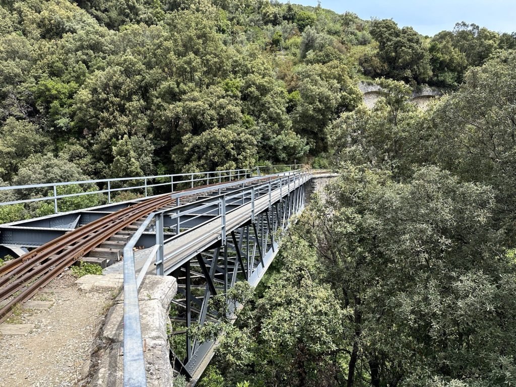 Brug van Chirico, Milies: oude, smalle metalen brug over groene kloof