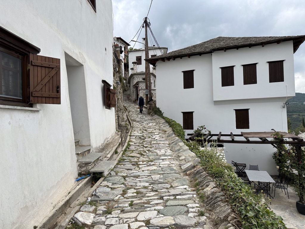 Smalle steeg ongelijk geplaveid en wit huis Makrinitsa, Pelion