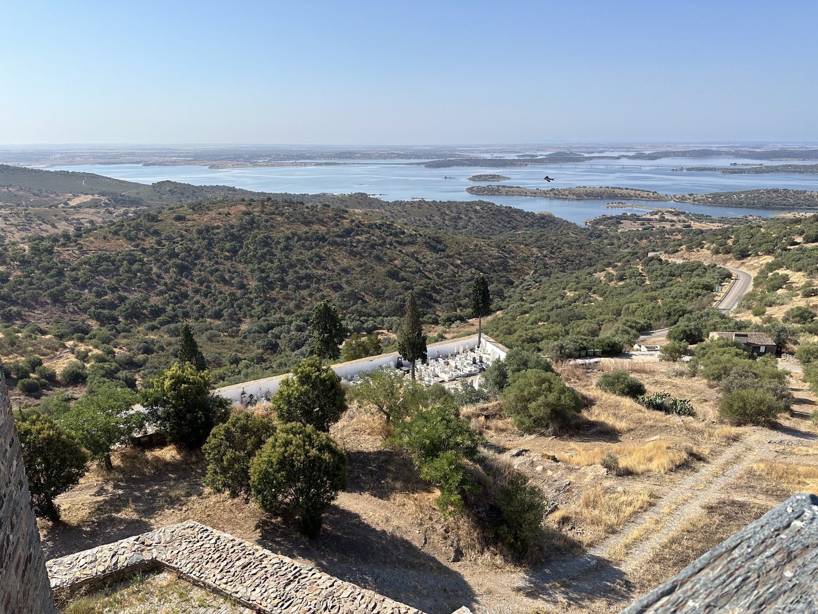 Panorama van meer van Alqueva met bossen en droge weilanden op de voorgrond en vanop Monsaraz, Alentejo
