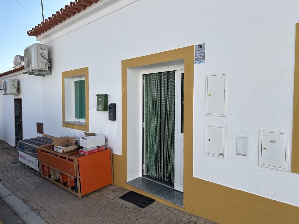 Wit huis, lege butaanflessen voor de gevel in Outeiro, Alentejo