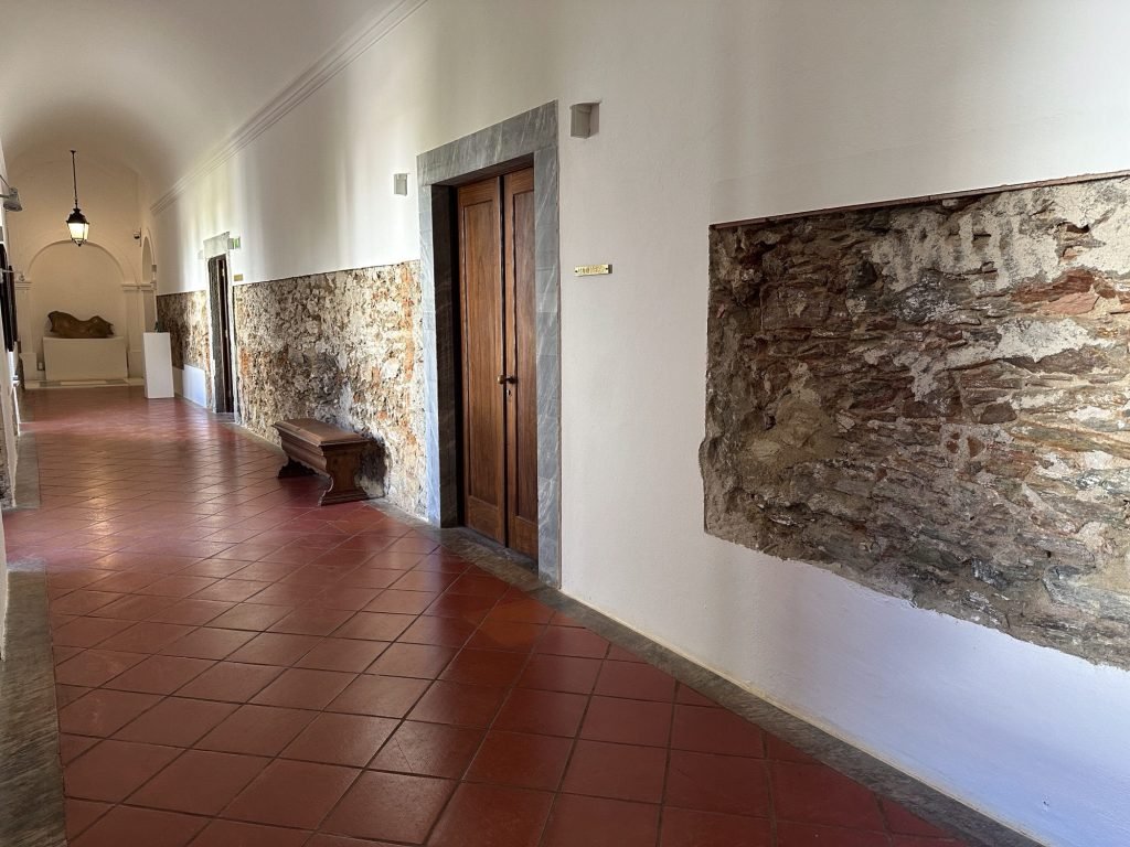 Gang in Convento da Orada, Monsaraz: witte muren met grote schilderijen