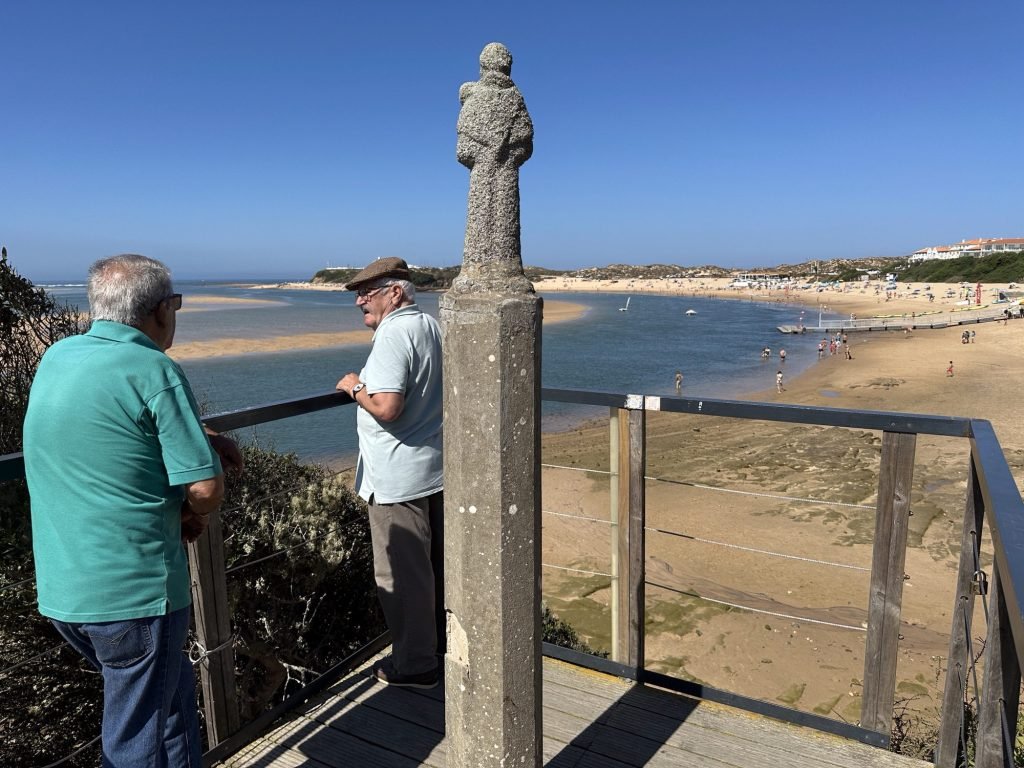 Twee oudere inwoners van Villanova de Milfontes kijken uit over de baai