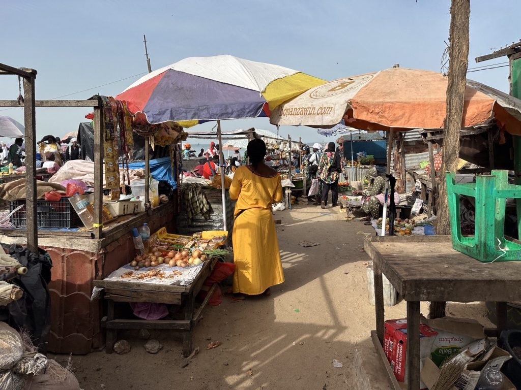 Marktkraampjes met veelkleurige parasols, groenten en fruit in Tanji