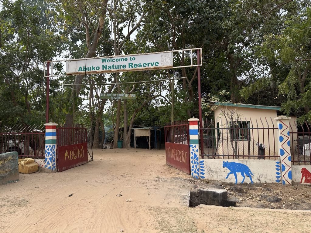 Ingang van Abuko Nature Reserve: klein gebouw, bomen, muurtje