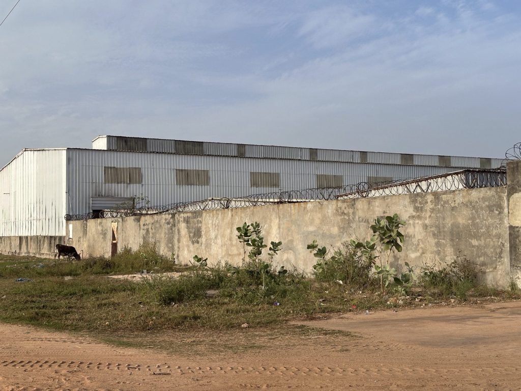 Sombere visverwerkingsfabriek met prikkeldraad op de muren