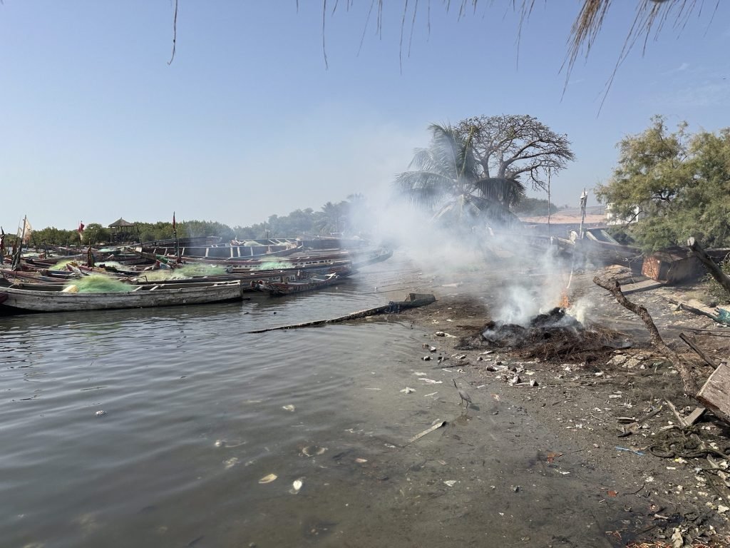 Brandende en rokende hoop riet naast Dodou’s restaurant