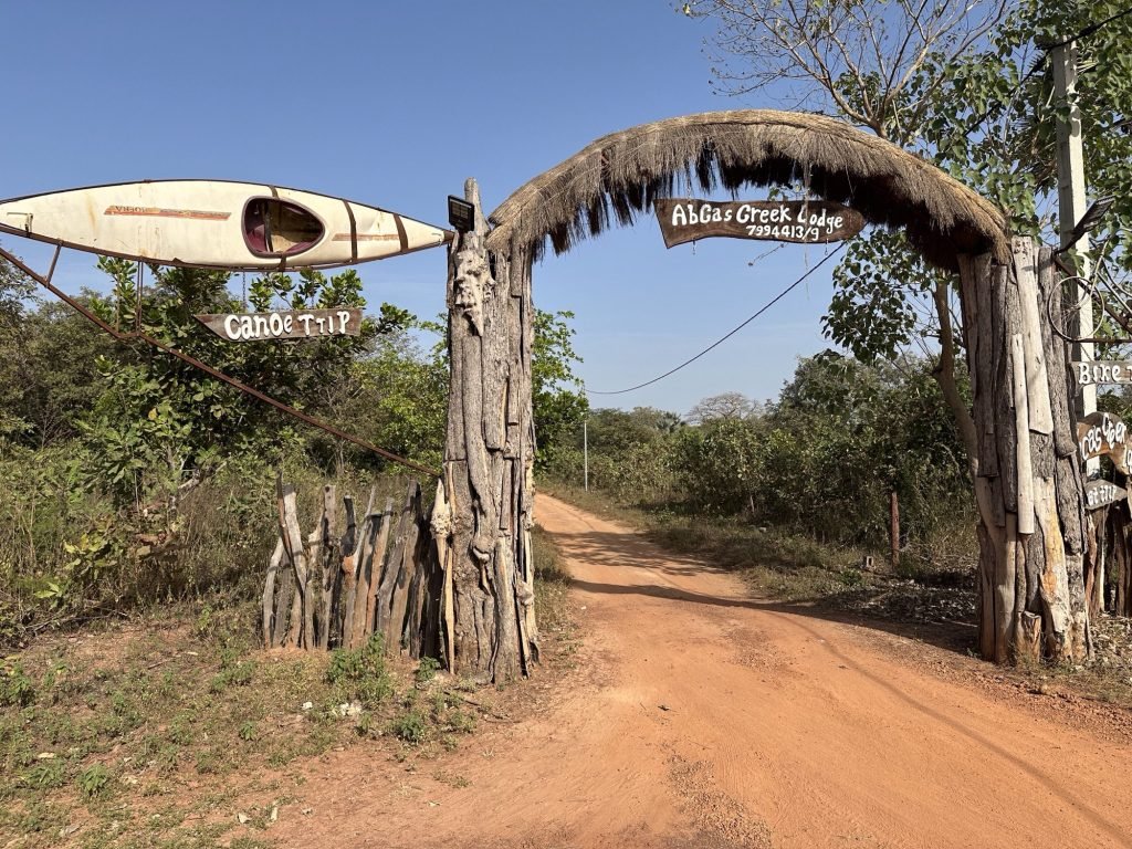 Toegangsweg tot Abca’s Creek Lodge met houten bord over de weg