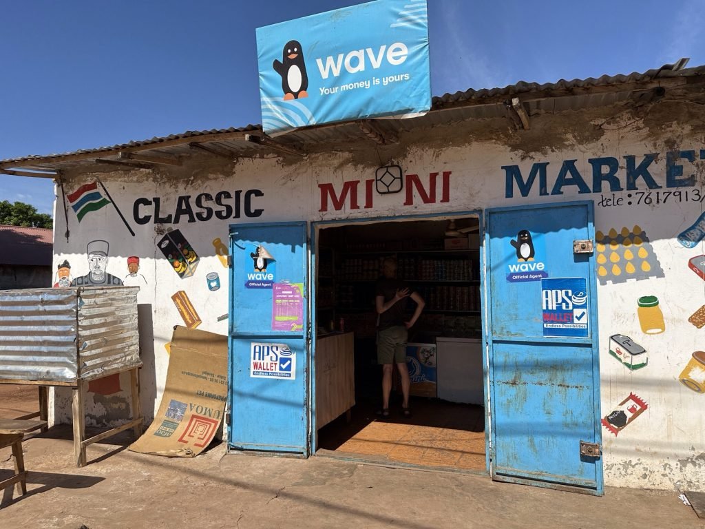 Mini-market met goflplaten en reclameborden in Gambia