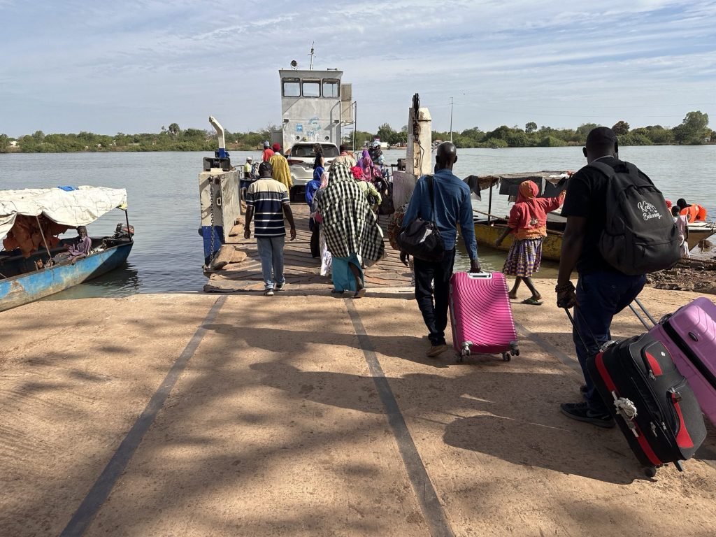 Voetgangers met valiezen stappen op de Bansang ferry
