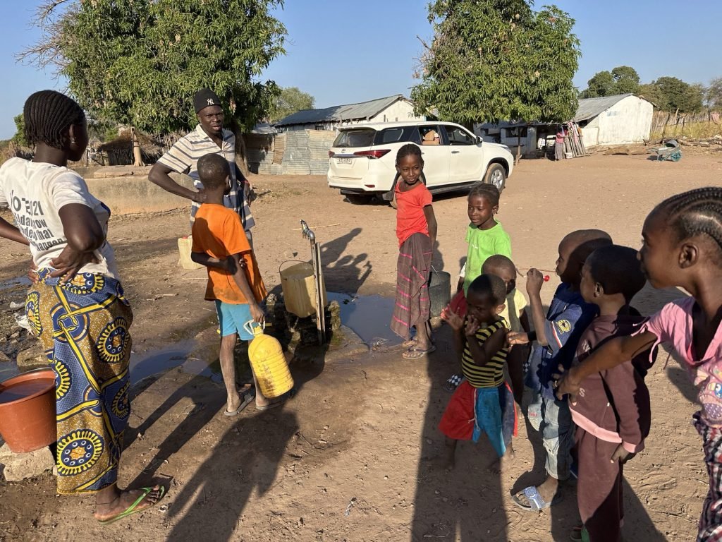 Afrikaanse kindjes rond een waterput met kraantje
