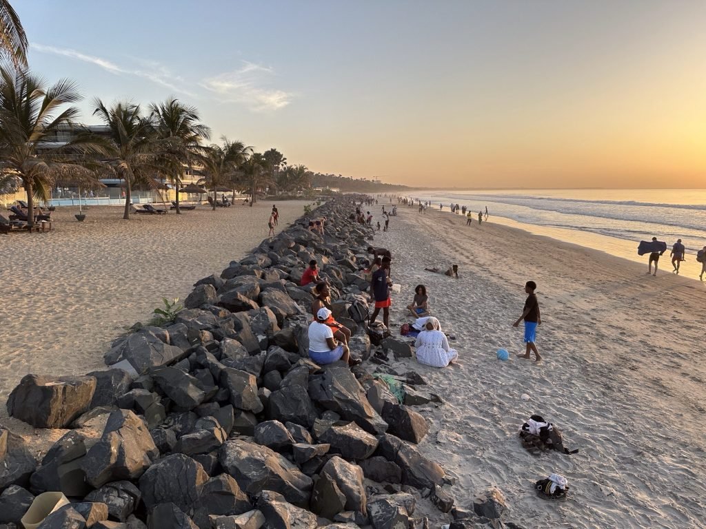 Strand van Kololi Beach met een wal van rotsblokken