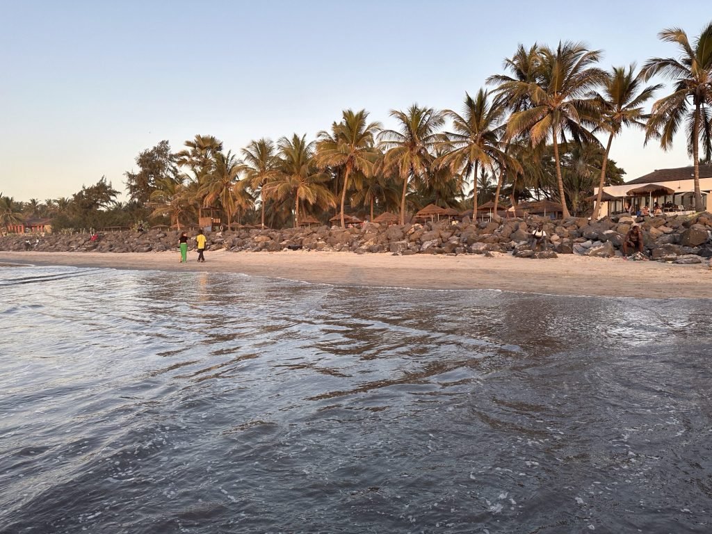 Kololi Beach met zee op voorgrond en palmbomen op achtergrond