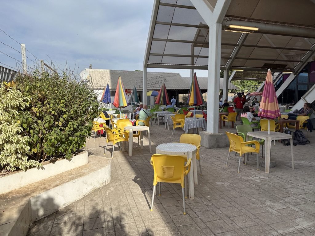 Terras van de bar van de luchthaven van Banjul met gele stoelen