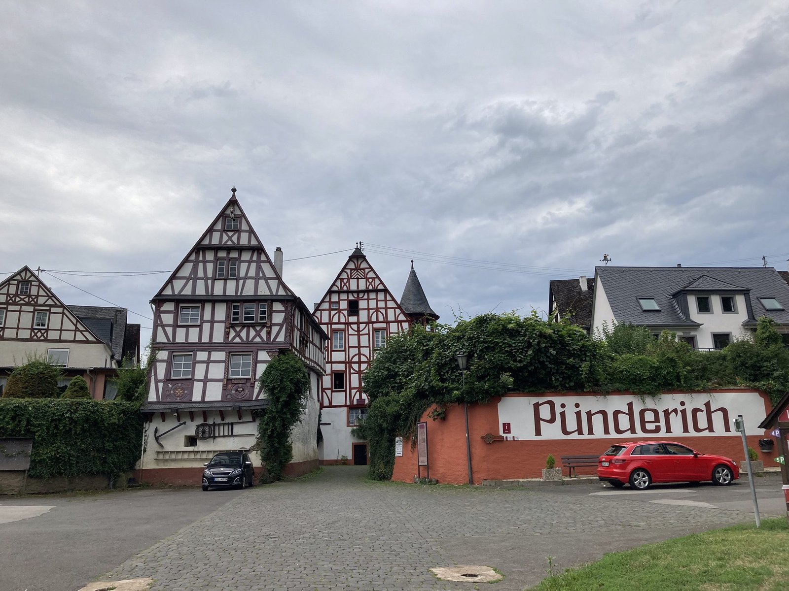 Twee vakwerk huizen en rode muur met opschrift Pünderich.