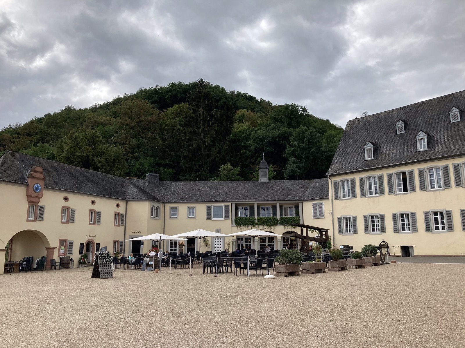 Binnenplein van Kloster Machern: beige gebouwen met witte parasols er voor.