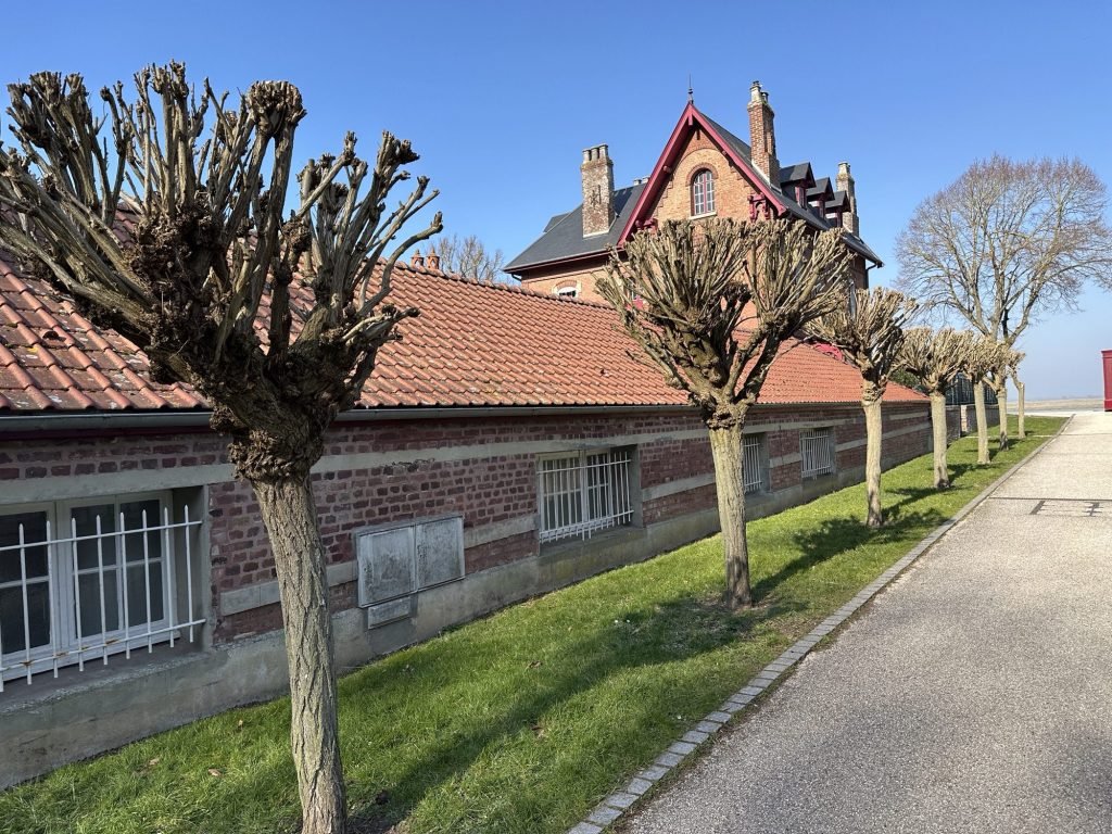 Langwerpig laag huis aan de strandboulevard en met rood pannendak