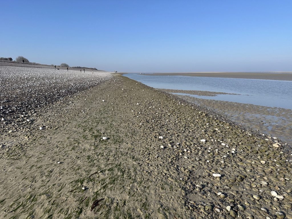 Strand met veel keien in de baai van de Somme