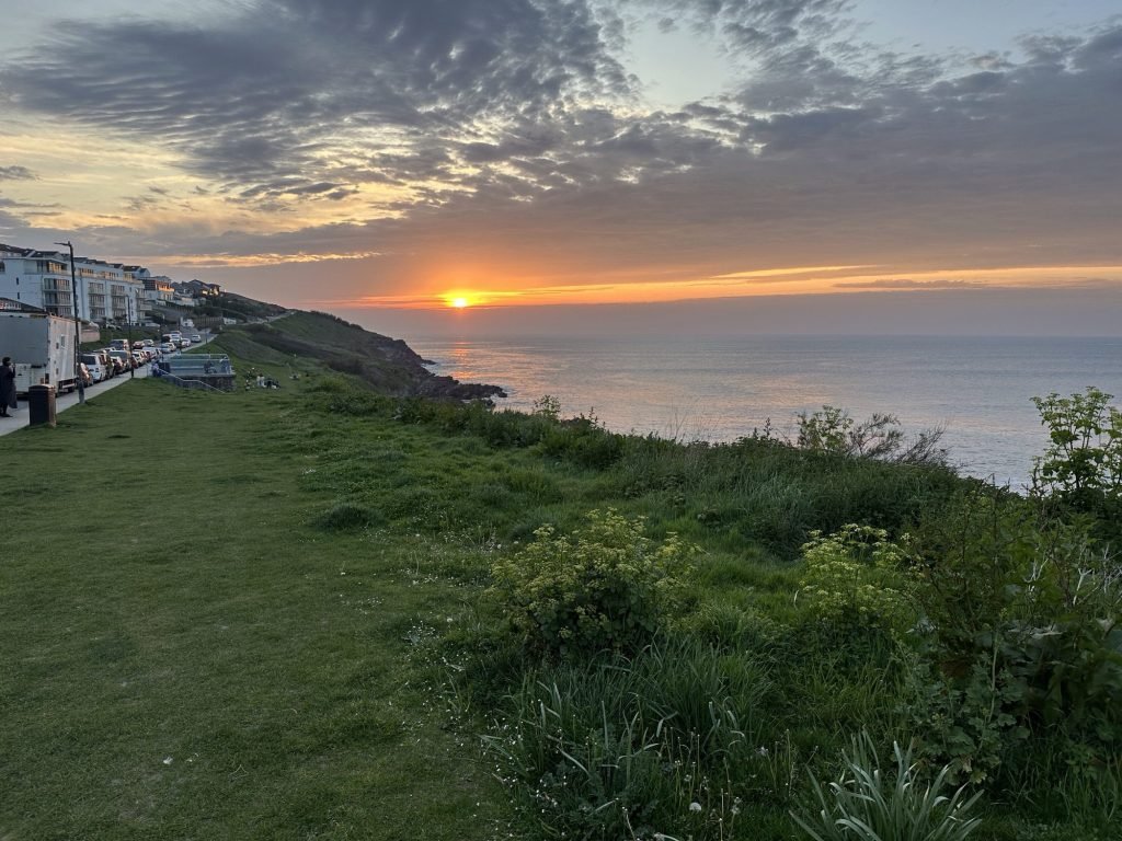 Zonsondergang in Newquay met surfer