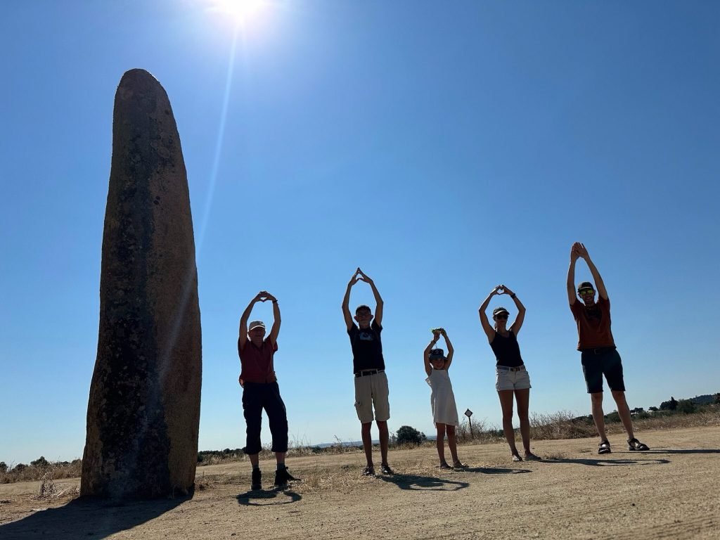 Menhir do Outeiro, Alentejo en vijf toeristen die met hun schaduw de menhir nabootsen