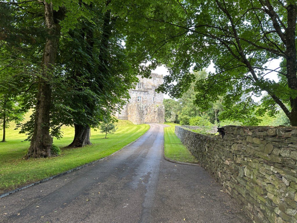 Oprijlaan met bomen naar kasteel. 
