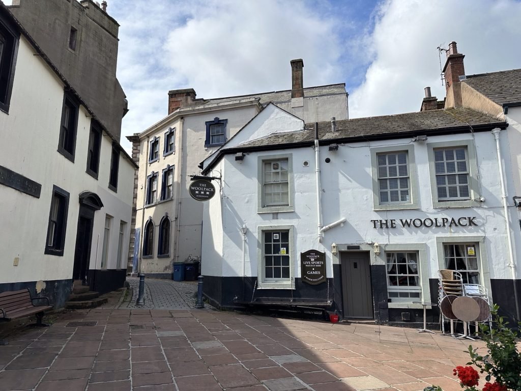 Pleintje met witte huizen en pub. 