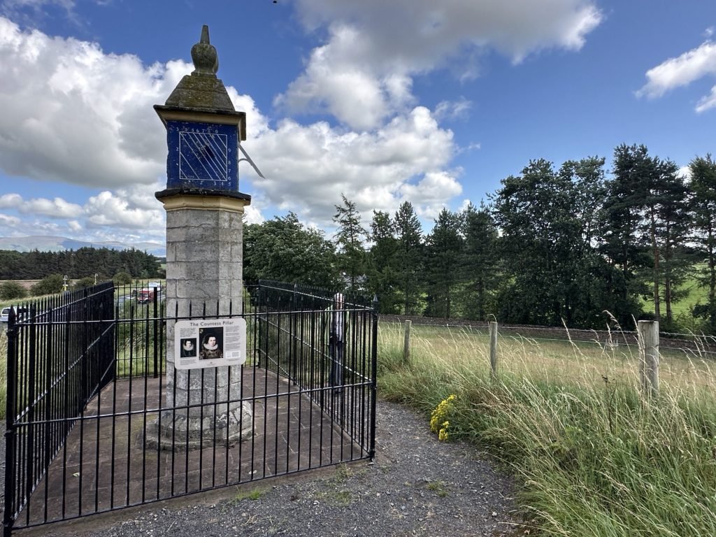 Versierde paal met hek rond in de natuur. 