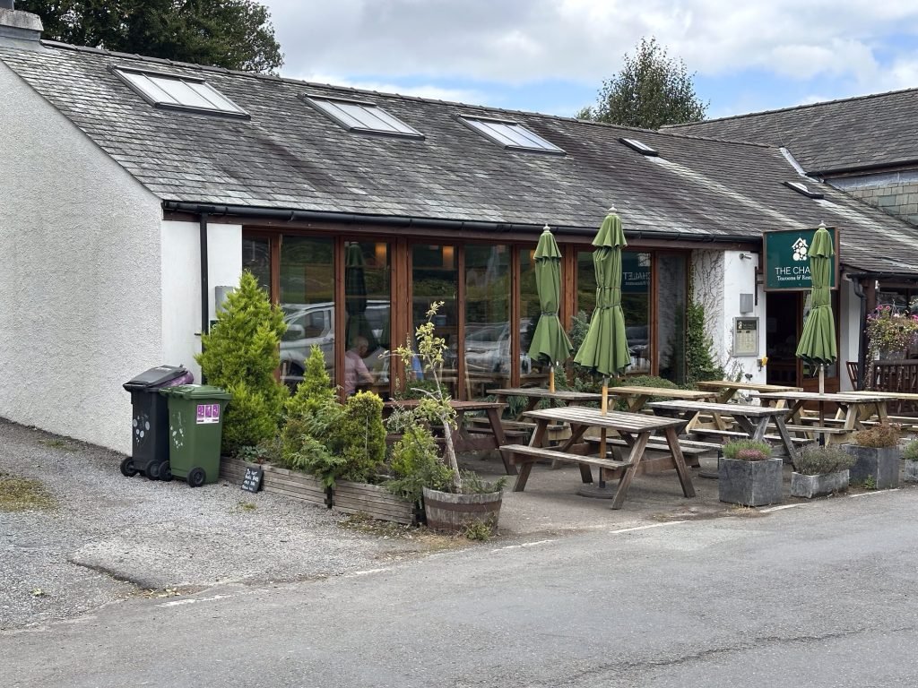Caféterras met houten banken en tafels. 