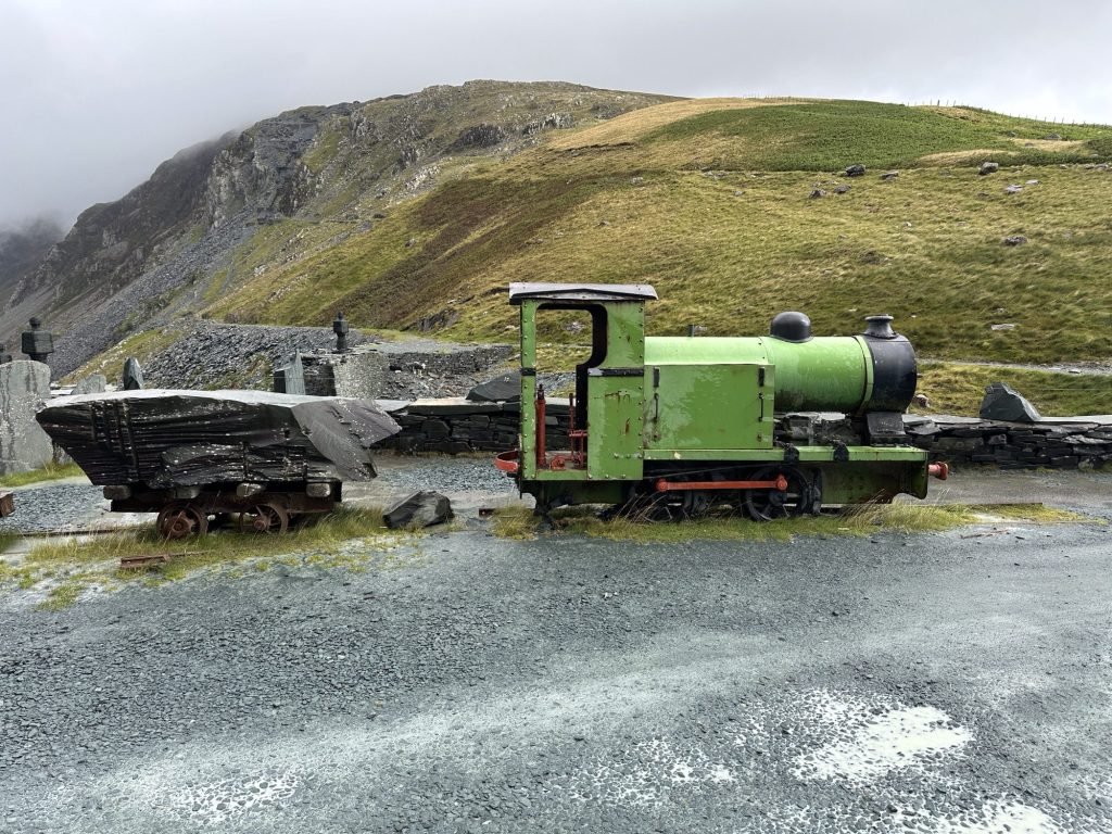 Groen stoomlocomotiefje met karretje met leisteen.