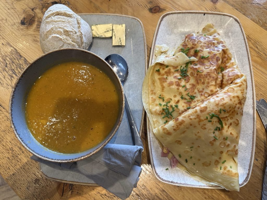 Groot bord soep met gevulde pannekoeken. 