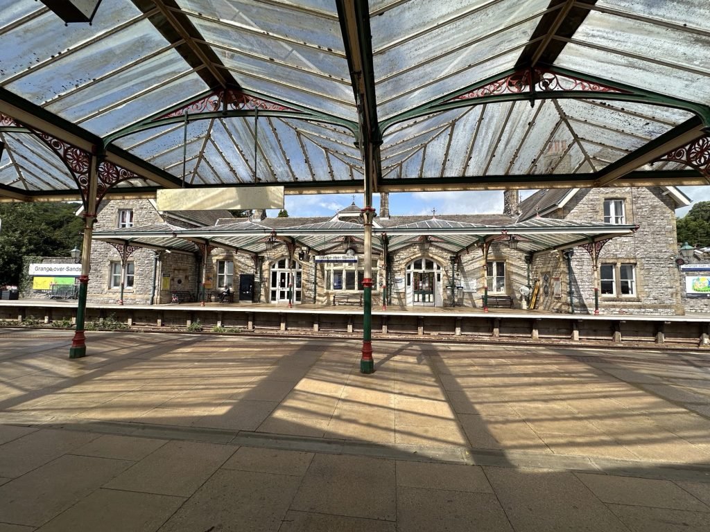 Glazen perronluifel met station op achtergrond. 