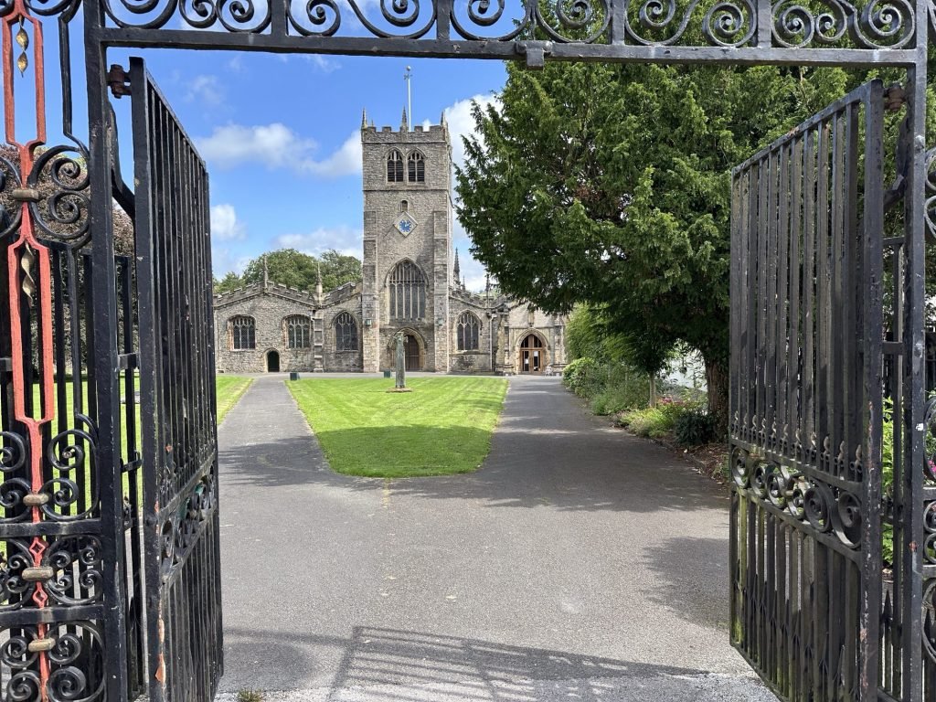 Vooraanzicht van kerk tussen open ijzeren hekken. 
