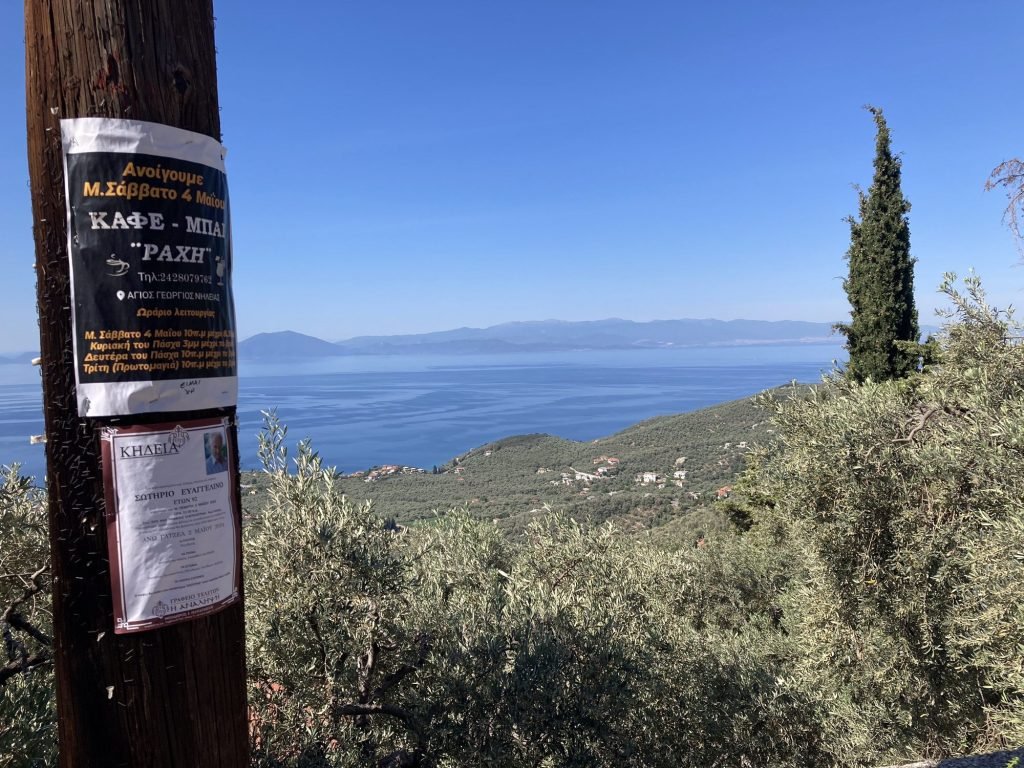 Blauwe baai in Pelion, Centraal Griekenland met overlijdensberichten op electriciteitspaal