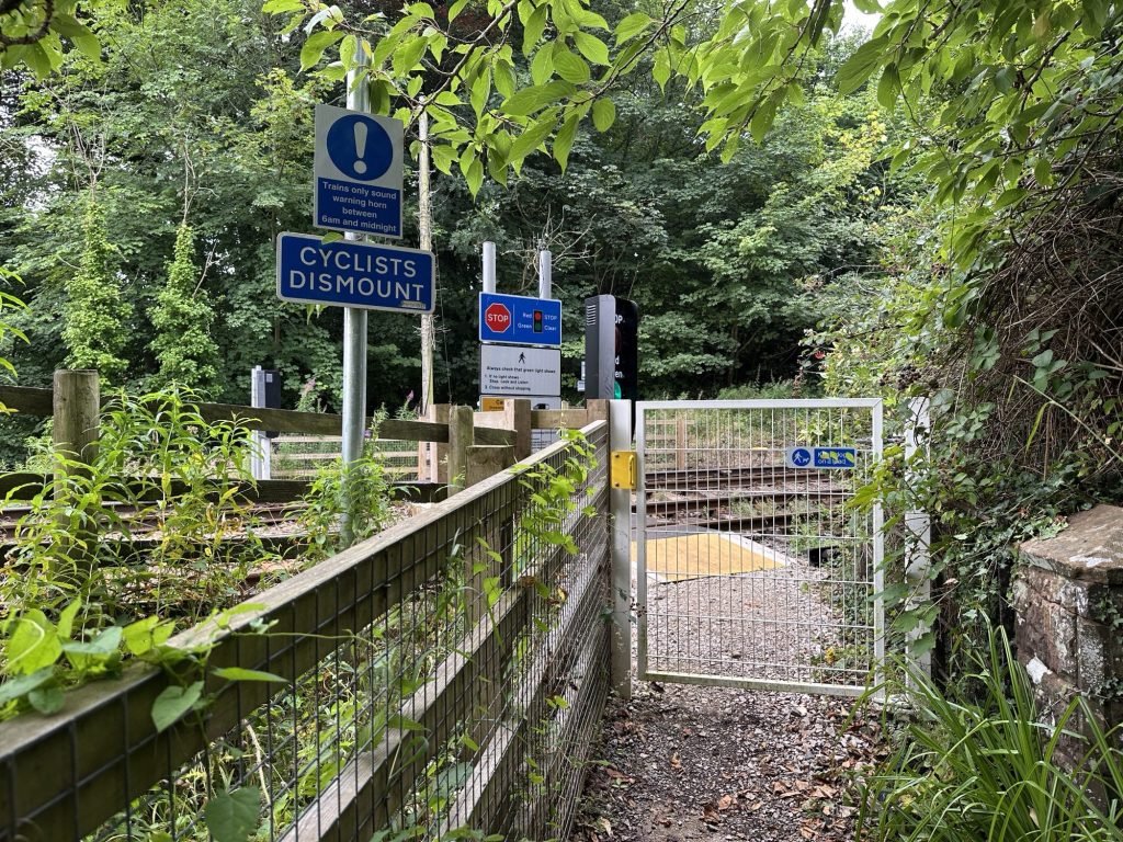 Ijzeren hek en waarschuwingsborden voor spoorweg.